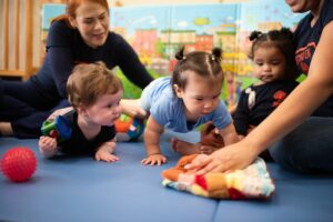 INIC preschool infants during tummy time with teachers