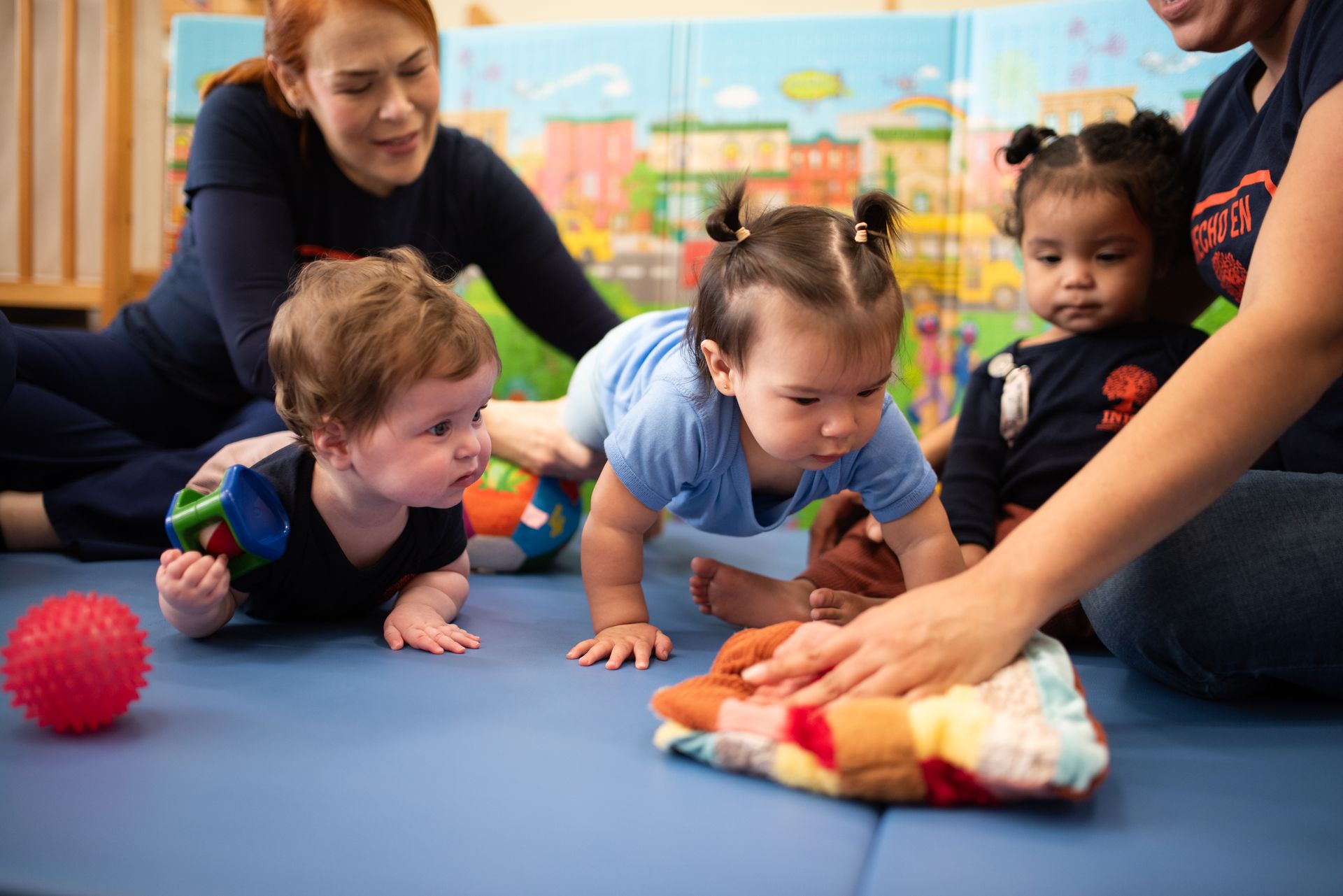 INIC preschool infants during tummy time with teachers